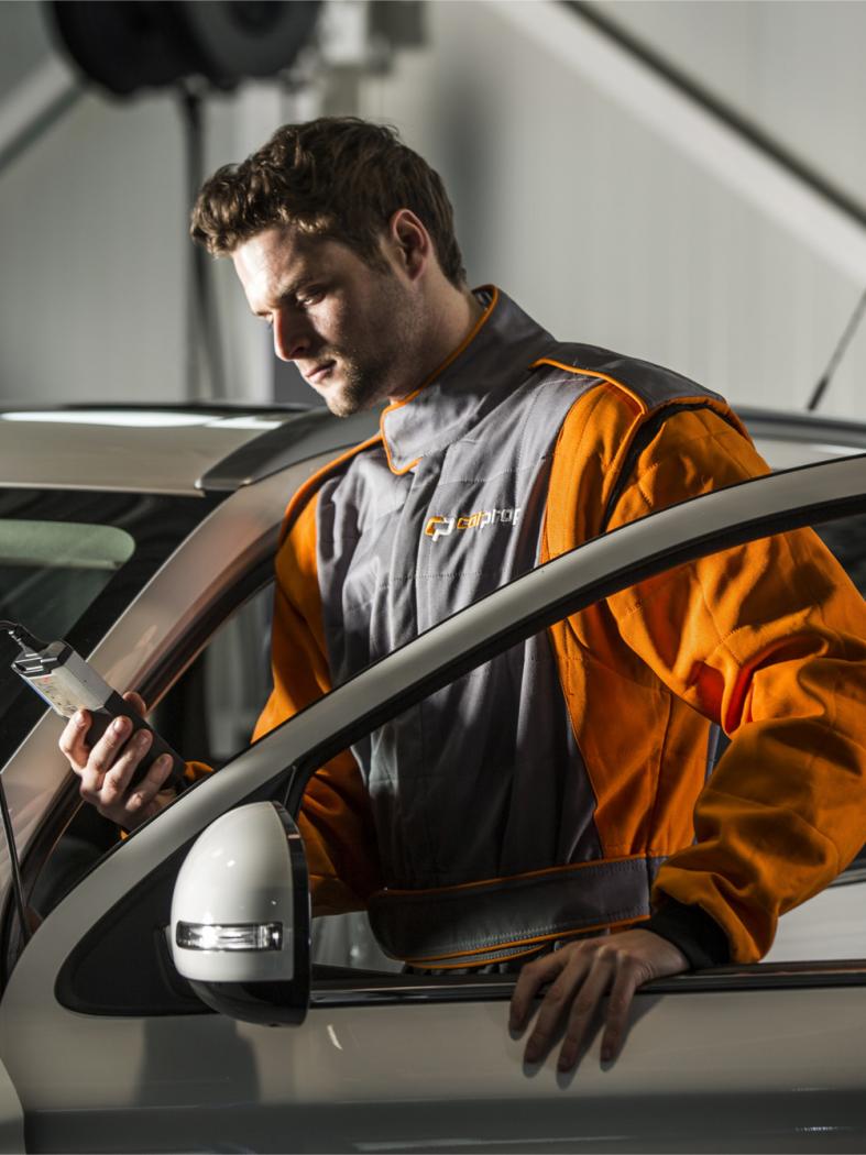CarProf monteur kijkt bij auto op apparaat
